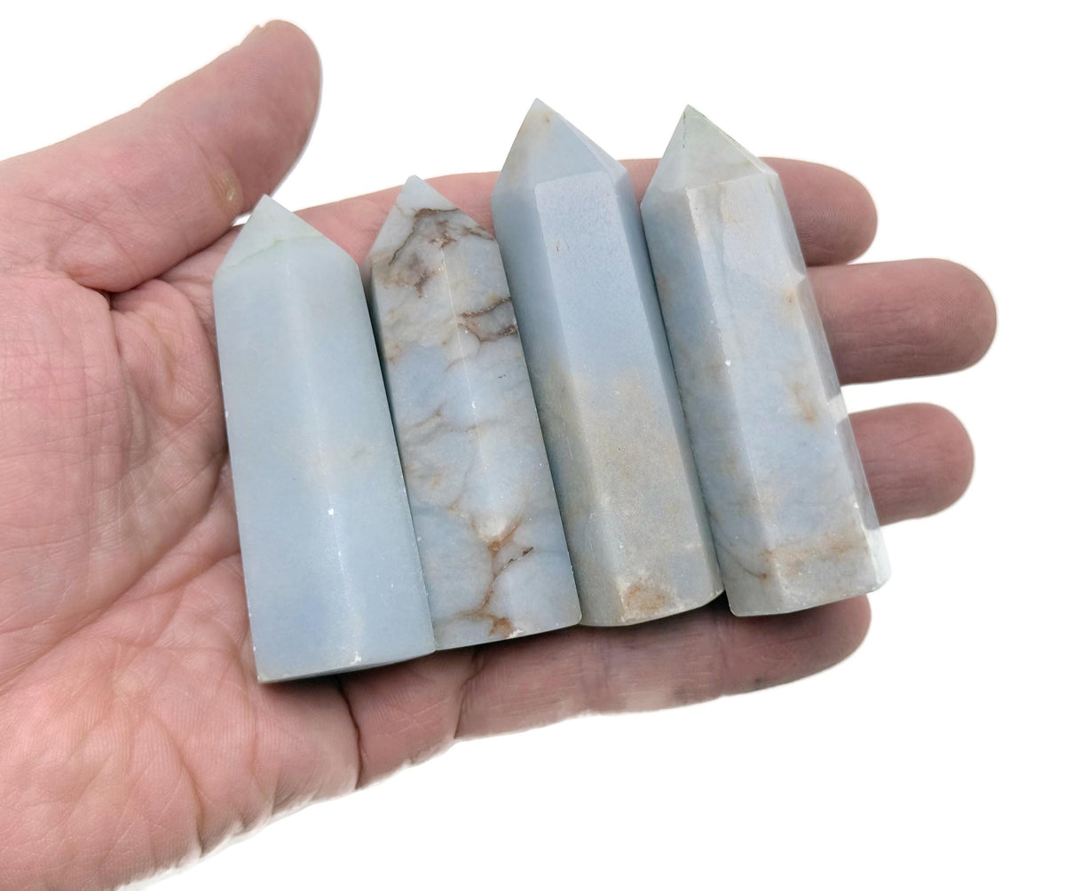 Angelite obelisk tower crystal from GemstoneGO, showcasing smooth light blue stone with natural veining and polished pointed top.