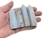 Angelite obelisk tower crystal from GemstoneGO, showcasing smooth light blue stone with natural veining and polished pointed top.