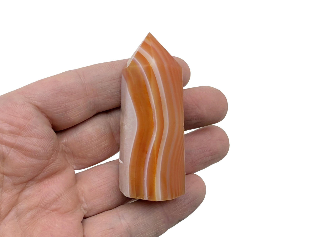 Carnelian obelisk tower crystal by GemstoneGO, featuring a polished, deep orange gemstone shape with natural stone details.