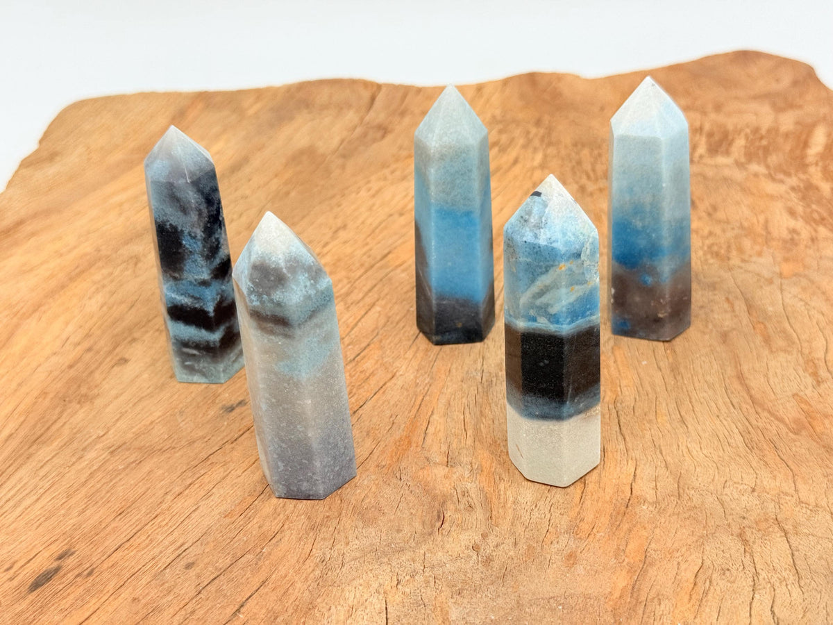 Trolleite obelisk tower crystal from GemstoneGO, showcasing blue-green mineral with natural crystal formation and pointed shape.