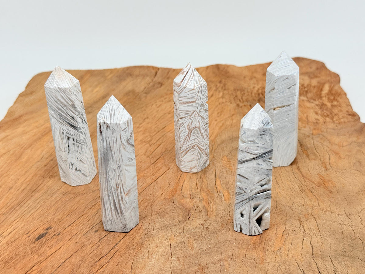 Mexican White Agate obelisk tower crystal from GemstoneGO, showcasing smooth, polished white stone with natural banding and unique patterns.