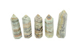 Caribbean green calcite obelisk tower crystal from GemstoneGO, showing smooth polished surface and vibrant green color.