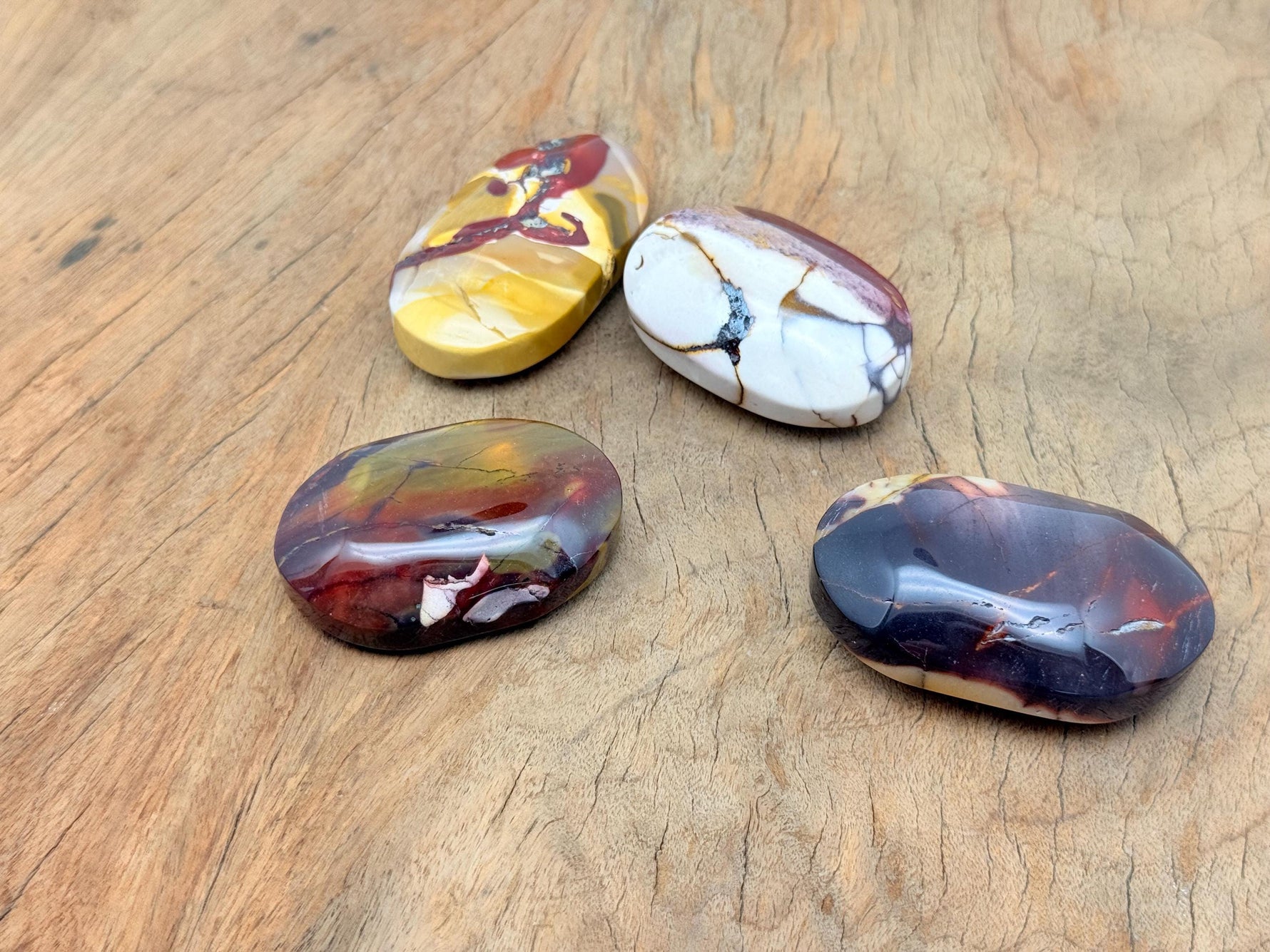 Mookaite Jasper palm gemstone spa stone from GemstoneGO, showing its polished, multicolored natural Jasper surface.