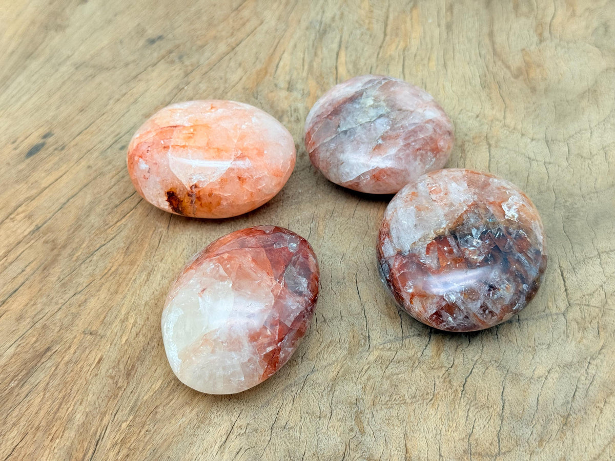 Red Hematoid Quartz Fire Quartz palm gemstone, spa stone with polished surface, vibrant red and clear crystal details.