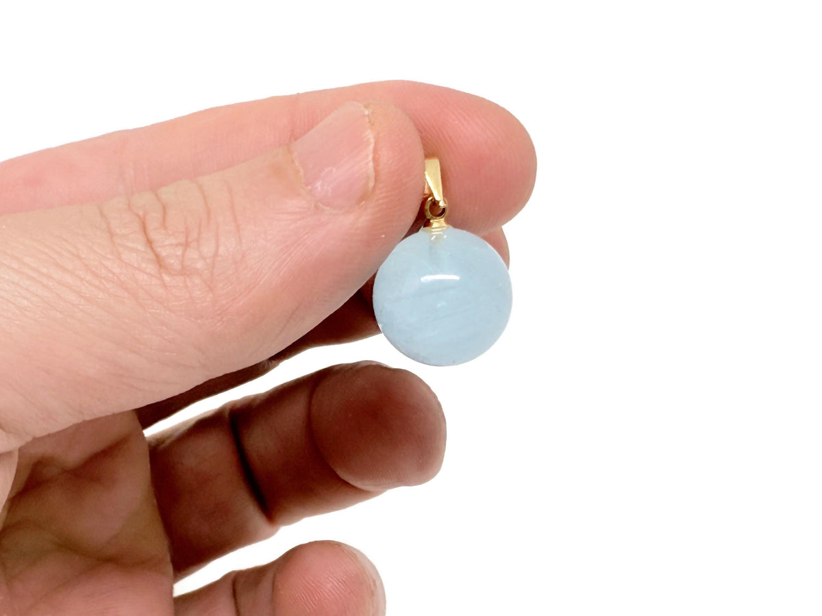 Aquamarine ball crystal pendant showing a smooth, round gemstone with a silver bail, symbolizing clarity and inner peace.
