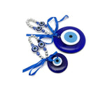 Blue glass evil eye charm with intricate design, Turkish Nazar amulet for protection and healing, ideal for home decor.