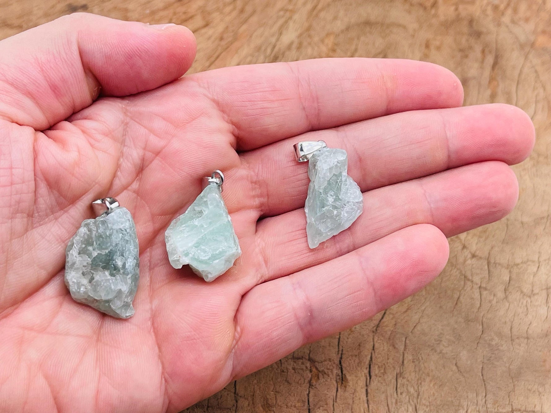 Fluorite crystal pendant from GemstoneGO featuring a vibrant green and purple gemstone on a silver chain.