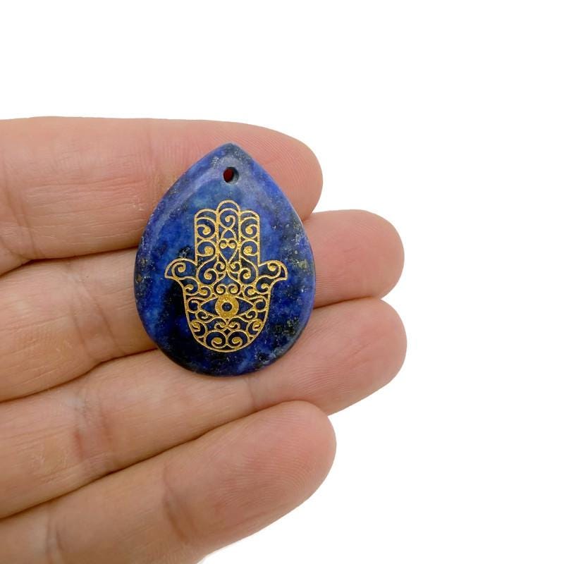 Engraved crystal Hamsa Hand pendant from GemstoneGO, featuring drilled design for protection, luck, and spiritual energy.