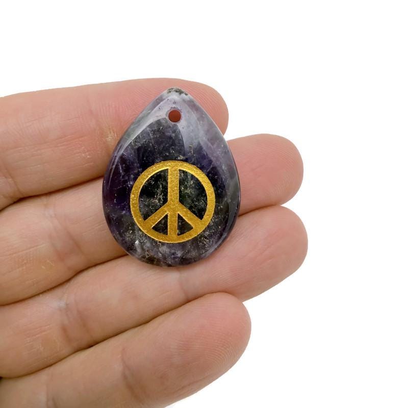 Crystal peace symbol charm with engraved design, drilled for jewelry, representing calm, harmony, and positive energy.