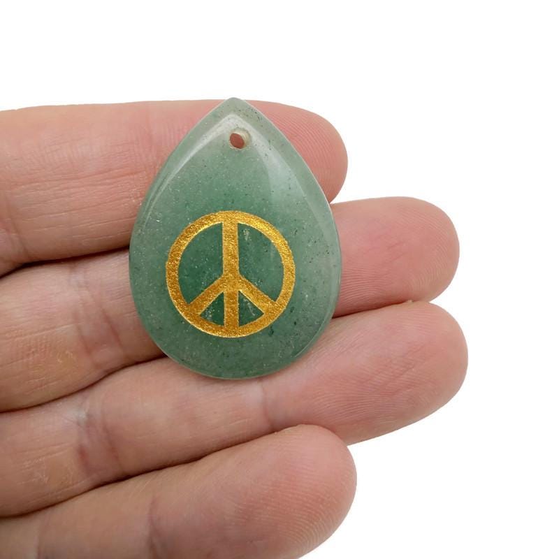 Drilled crystal charm with peace symbol engraving from GemstoneGO, designed for calm, harmony, and positive energy.