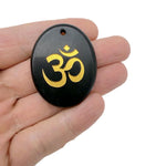 Crystal amulet with engraved Om symbol, drilled for hanging, representing spiritual insight and guidance from GemstoneGO.