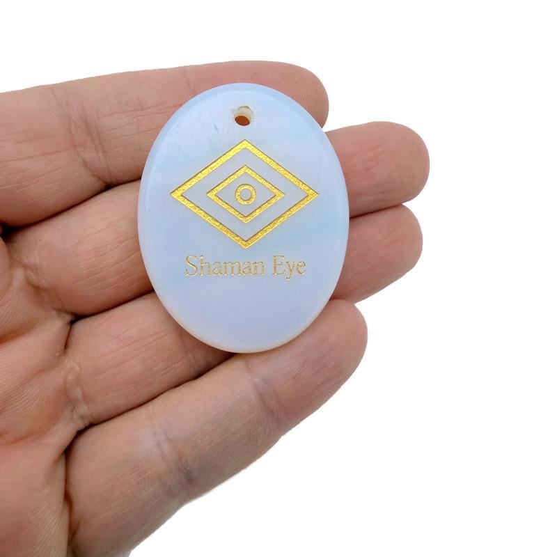 Shaman Eye engraved crystal from GemstoneGO, drilled for intuitive energy protection, with intricate eye design and polished surface.