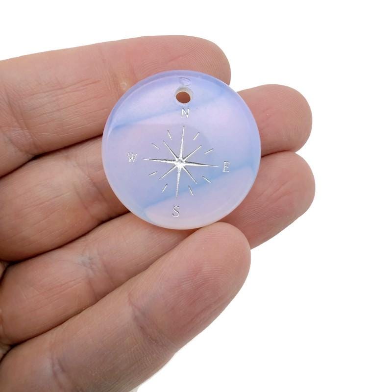 Engraved crystal compass pendant from GemstoneGO, featuring a drilled hole for necklace or keychain attachment.