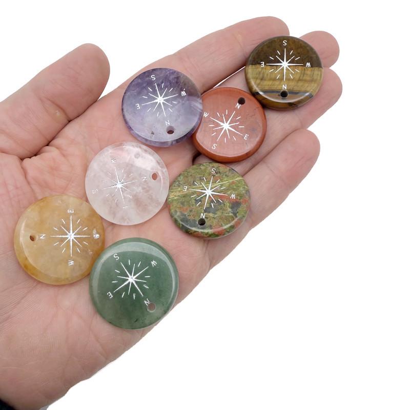 Engraved crystal compass pendant with drilled hole, ideal traveler gift, by GemstoneGO, showcasing detailed craftsmanship and crystal clarity.