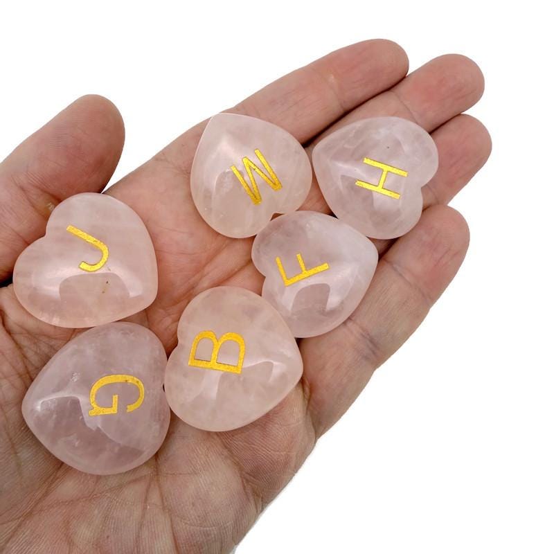 Rose quartz engraved crystal letter heart pendant with personalized initial, crafted by GemstoneGO, featuring a polished, heart-shaped design.