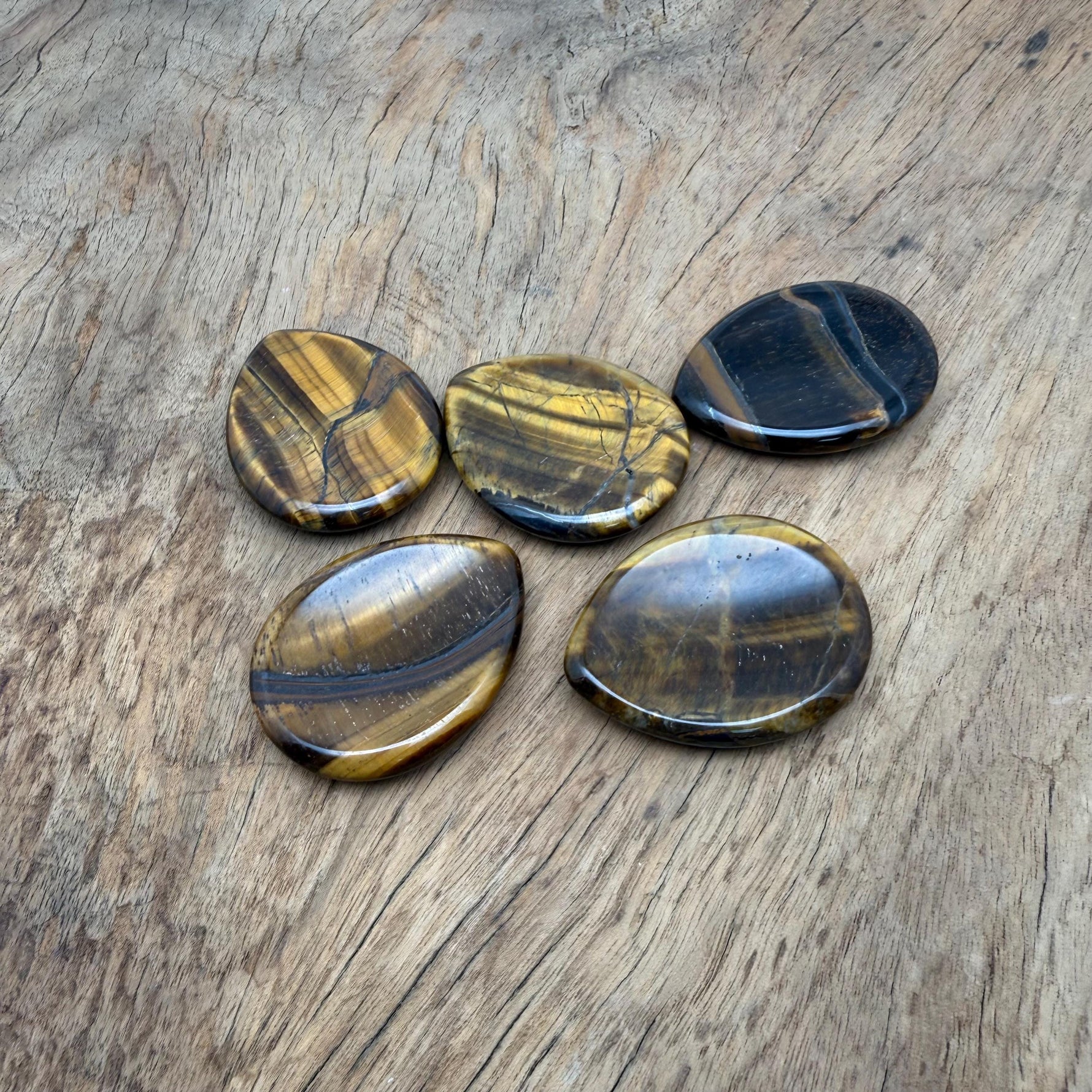 Smooth 45mm Tiger Eye worry stone from GemstoneGO, showcasing warm, layered brown and gold tones with polished surface.
