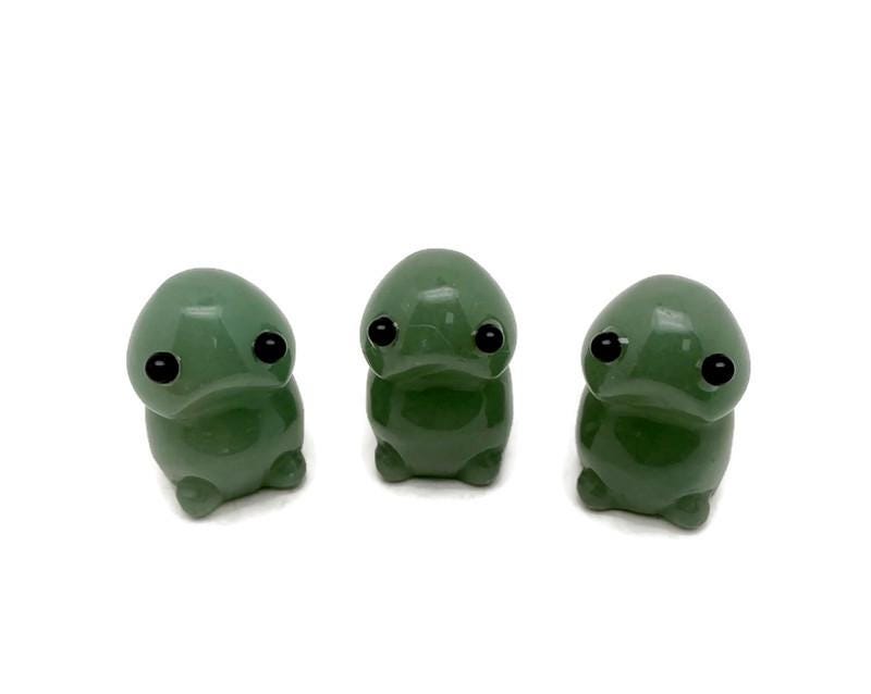Handcrafted aventurine frog monster crystal carving, gemstone creature statue with detailed features and vibrant green color.