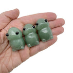 Handcrafted aventurine frog monster crystal carving, gemstone creature statue with detailed features and vibrant green color.