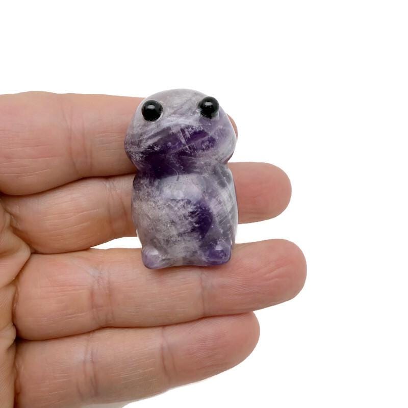 Handcrafted amethyst frog monster gemstone carving, detailed creature statue with vibrant purple hues and natural crystal formations.