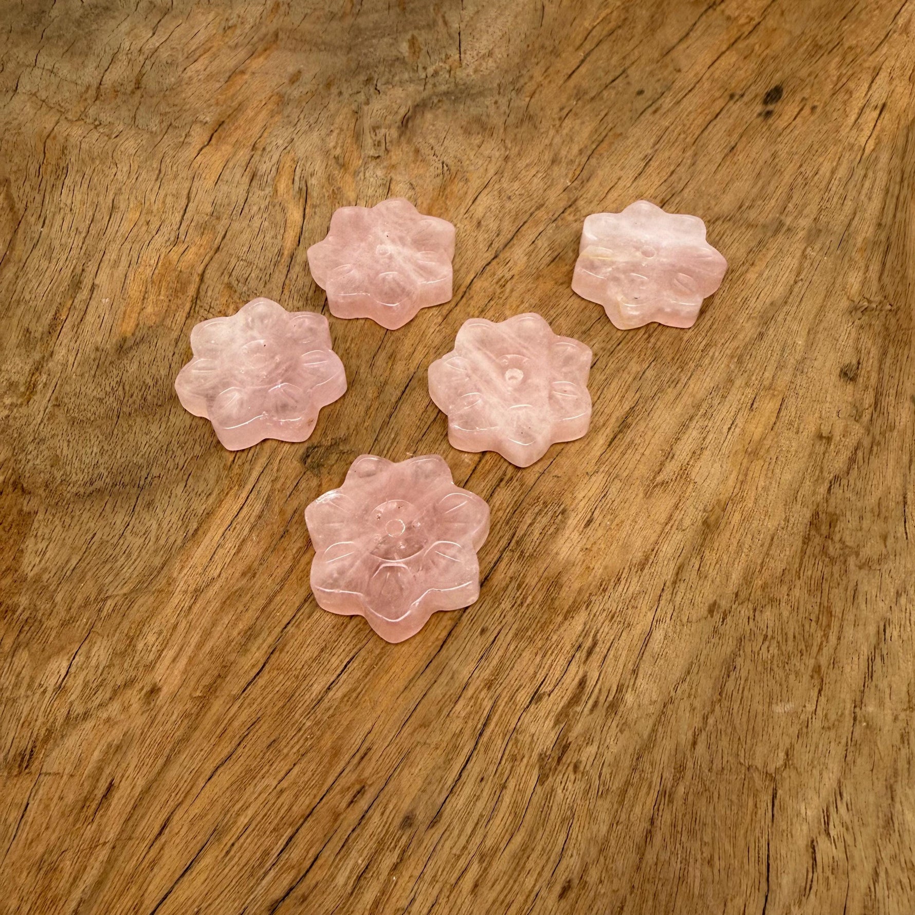 Rose quartz crystal flower incense holder with carved gemstone design for meditation and stick burning.