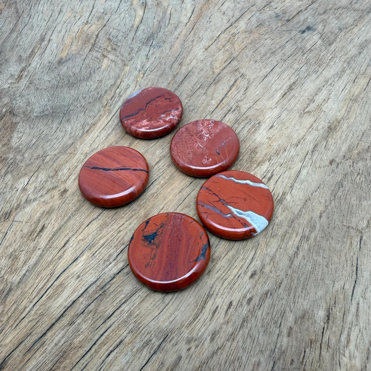 Round red jasper flat gemstone slab, 25mm, showing vibrant red color and smooth polished surface from GemstoneGO.