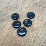 Polished 20mm obsidian crystal donut from GemstoneGO, showcasing a smooth, glossy black stone with natural patterns and a central hole.