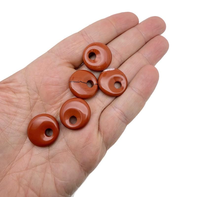 Red Jasper crystal donut pendant from GemstoneGO, 20mm Pi stone with polished red jasper surface and smooth, rounded shape.