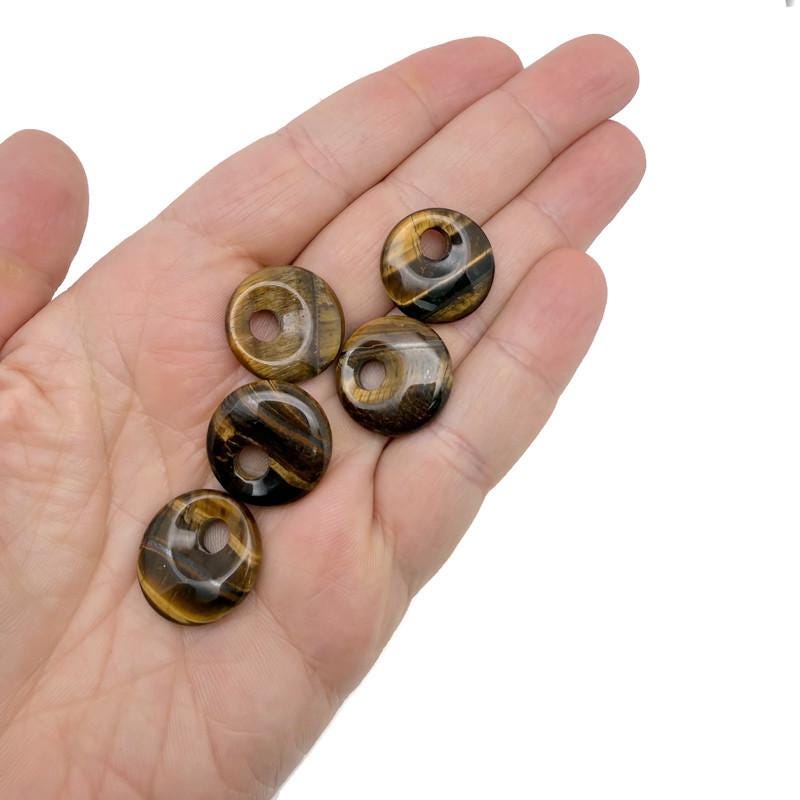 Tiger Eye crystal donut pendant from GemstoneGO, 20mm Pi stone with golden-brown chatoyancy and smooth, polished surface.