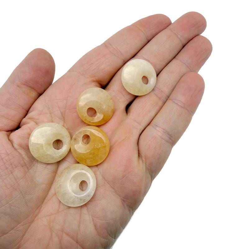 Yellow jade crystal donut pendant, 20mm Pi stone from GemstoneGO, smooth polished gemstone with a circular shape.