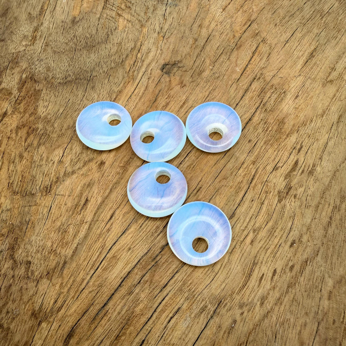 Opalite crystal donut pendant, 20mm Pi stone from GemstoneGO, showcasing a smooth, oval-shaped gemstone with a luminous, iridescent glow.