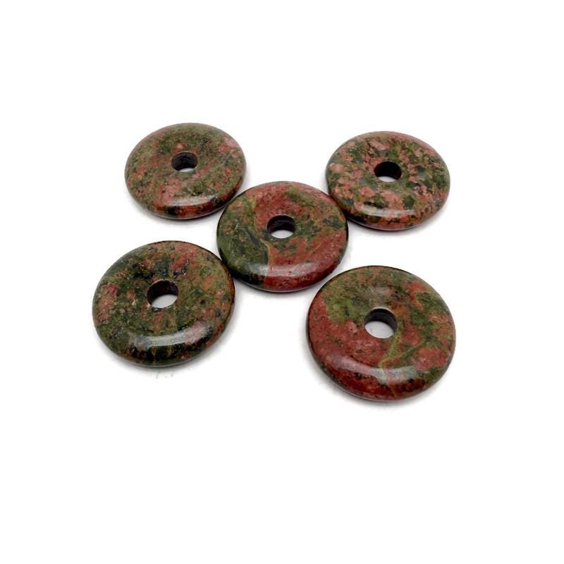 Unakite crystal donut pendant, 30mm Pi stone from GemstoneGO, showcasing pink and green marbled gemstone with smooth finish.