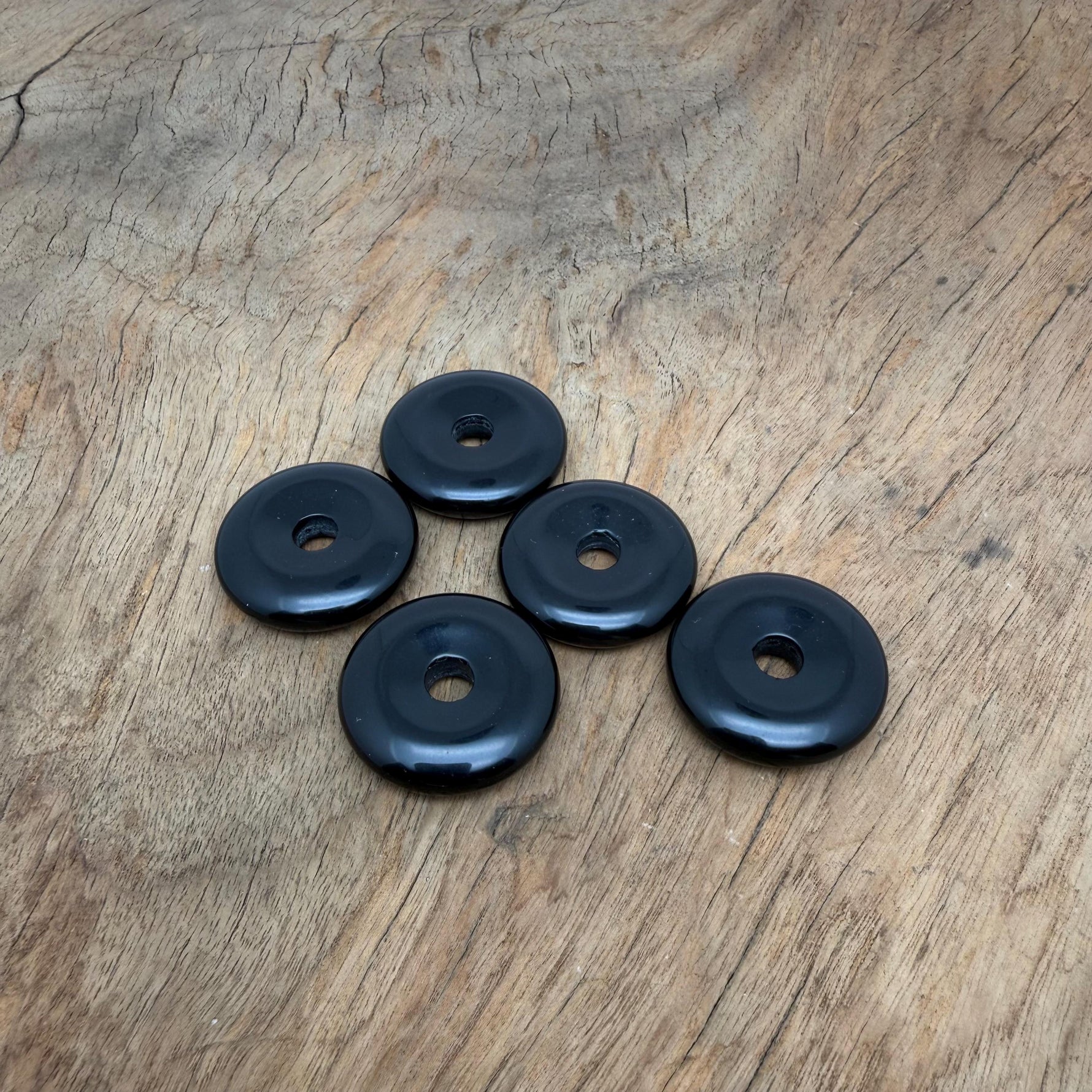 Obsidian crystal donut pendant from GemstoneGO, 30mm Pi stone with a smooth, polished black volcanic rock appearance.
