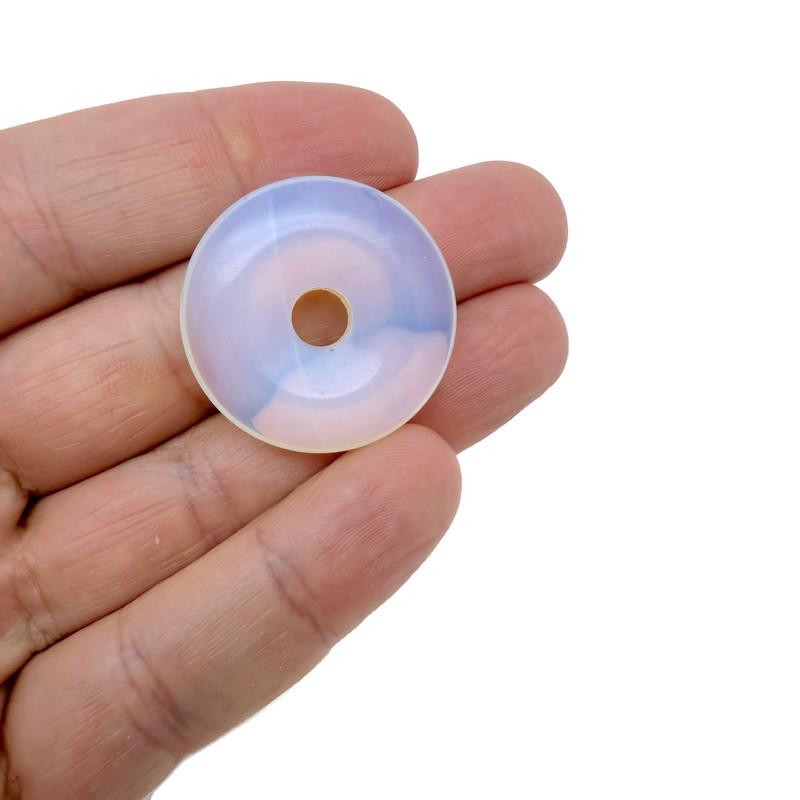 Opalite crystal donut pendant from GemstoneGO, 30mm Pi stone with smooth, polished surface and glowing, translucent appearance.