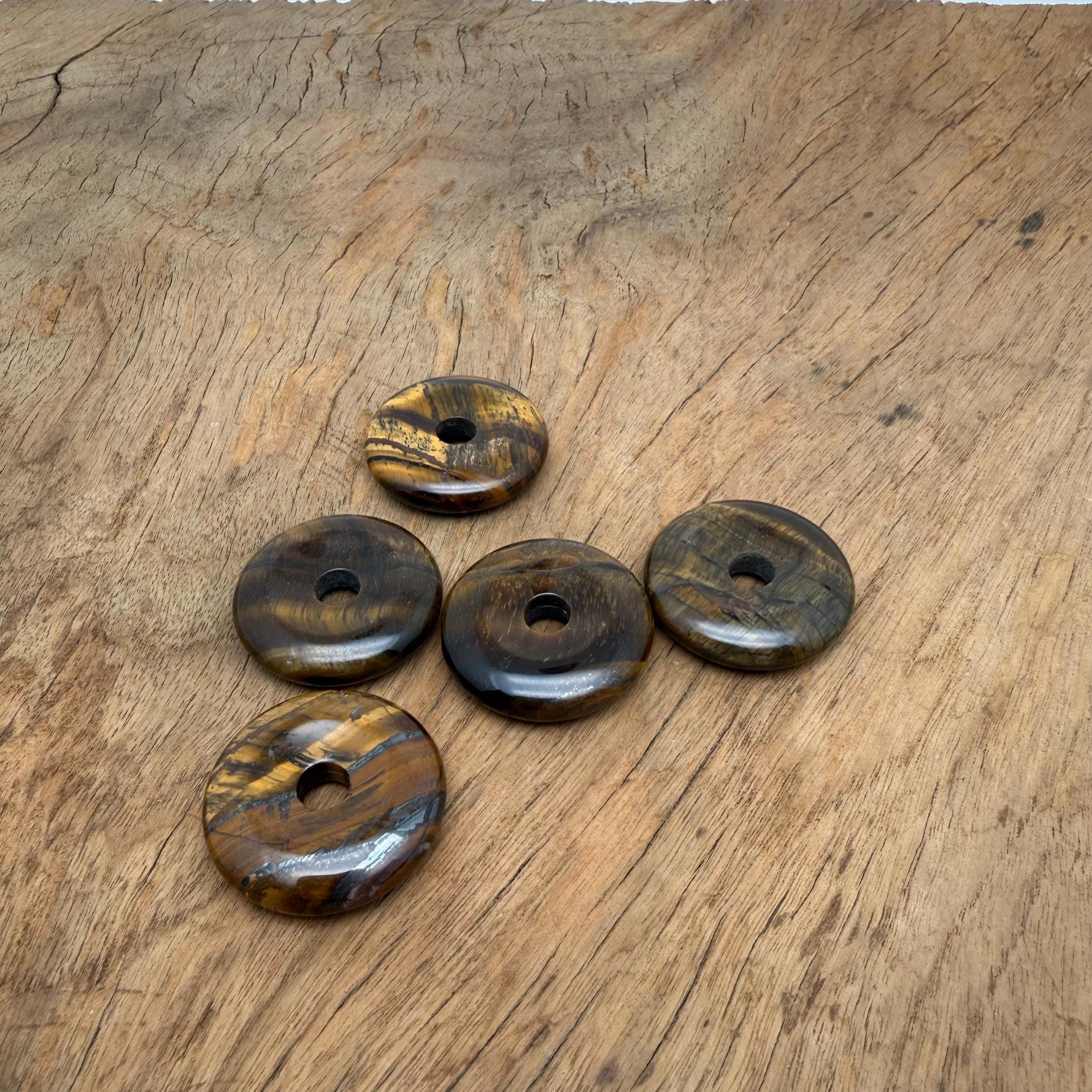 30mm Tiger Eye Crystal Donut Pi Stone by GemstoneGO showing a polished, golden-brown gemstone with distinctive banding and a central hole.