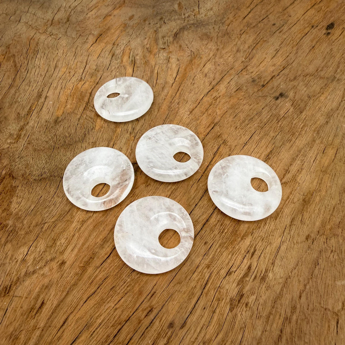 Clear Quartz Crystal Donut, 30mm Pi Stone from GemstoneGO, showcasing a polished, translucent gemstone with a hole in the center.