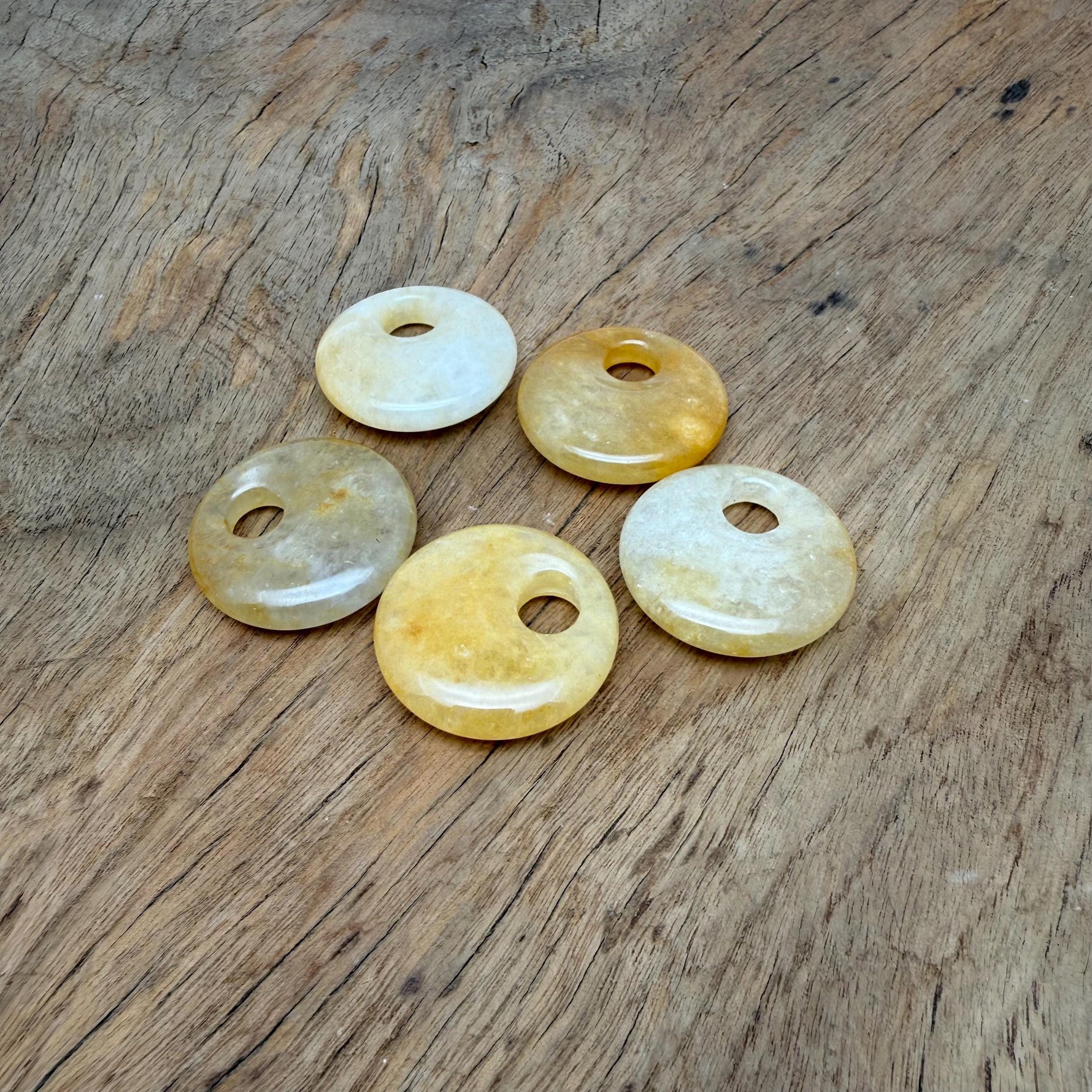 Yellow jade crystal donut pendant from GemstoneGO, 30mm Pi stone with a smooth, polished surface and vibrant yellow color.