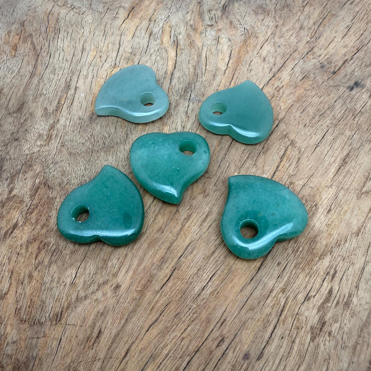 A 30mm Aventurine crystal heart with a hole, showcasing vibrant green gemstone with natural inclusions and smooth polished surface.