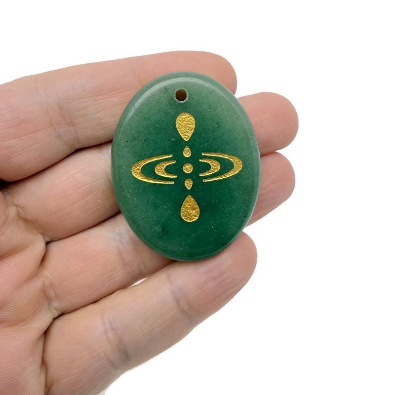 Drilled crystal amulet engraved with cosmic energy symbol, representing universe alignment, by GemstoneGO.
