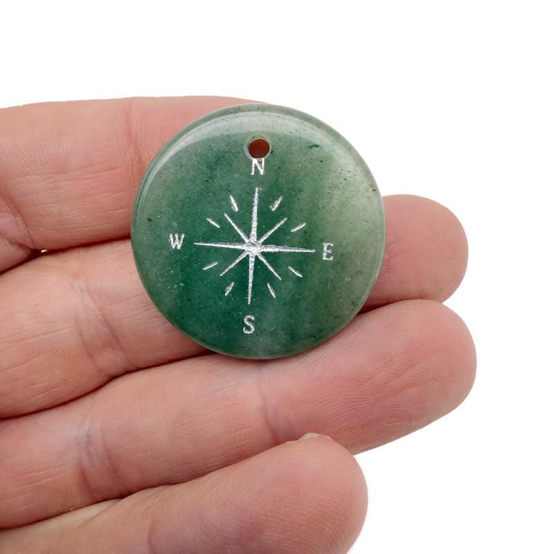 Engraved crystal compass pendant with drilled hole, perfect as a travel-themed gift from GemstoneGO.