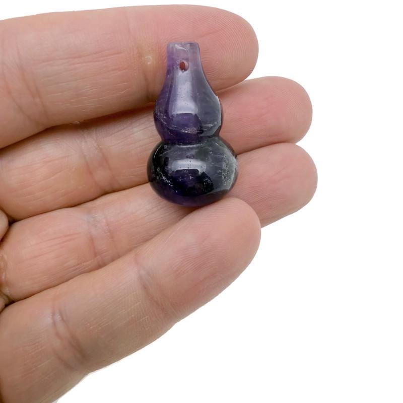 Wu Lou crystal pendant featuring a gemstone gourd design from GemstoneGO, displayed with its intricate carved details.