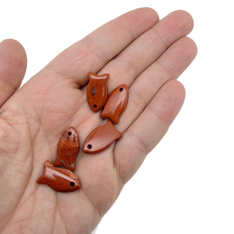 Red Jasper fish-shaped crystal pendant with healing stone charm, featuring a vibrant red gemstone and detailed fish design.