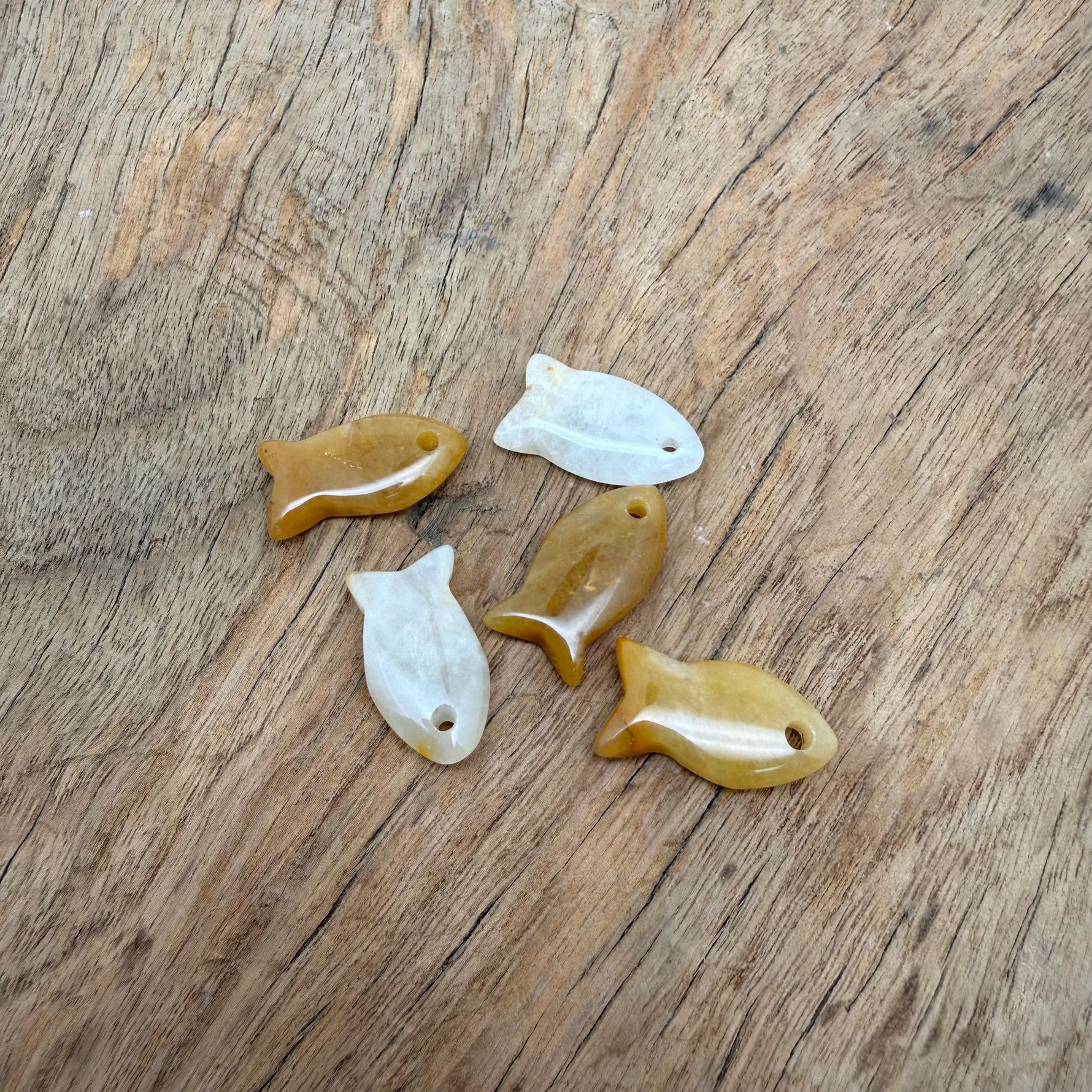 Yellow jade fish-shaped crystal pendant from GemstoneGO featuring a healing stone fish charm for jewelry.