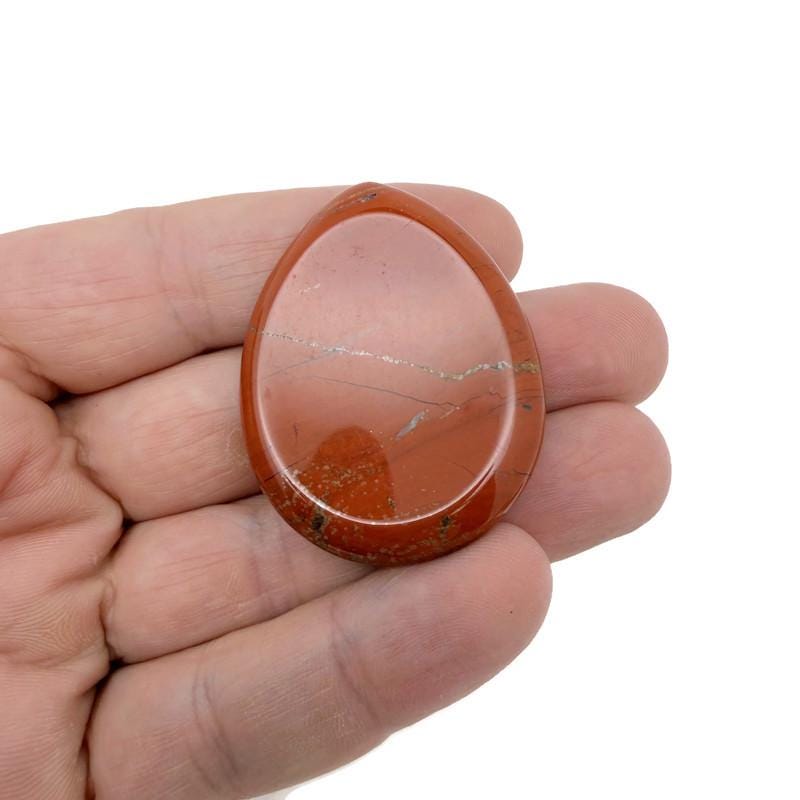 Red Jasper worry stone from GemstoneGO, 45mm, smooth polished crystal for stress relief and grounding, shown in a close-up image.