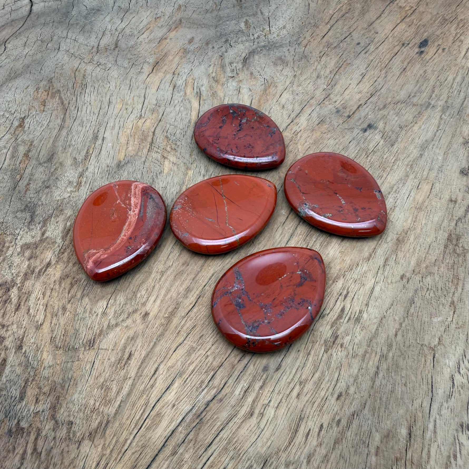 Red Jasper worry stone from GemstoneGO, 45mm smooth crystal with polished finish, used for calming and stress relief.