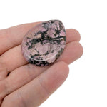 Rhodonite worry stone from GemstoneGO, 45mm soothing crystal with polished pink and black veined surface for stress relief.
