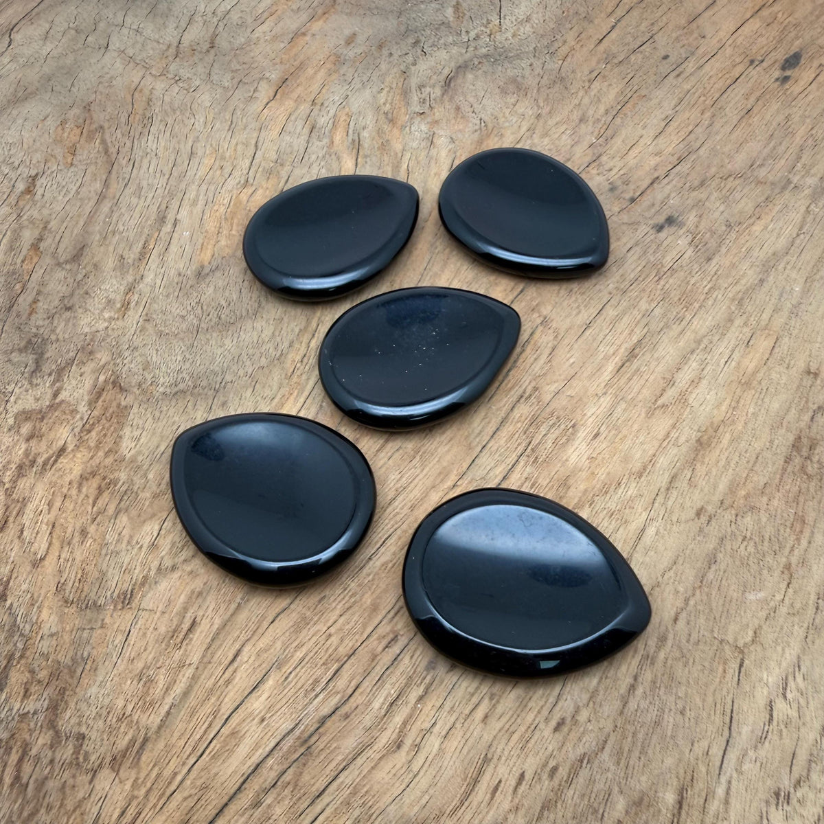 Obsidian worry stone from GemstoneGO, 45mm smooth crystal for stress relief, shown in close-up with polished surface and natural black color.