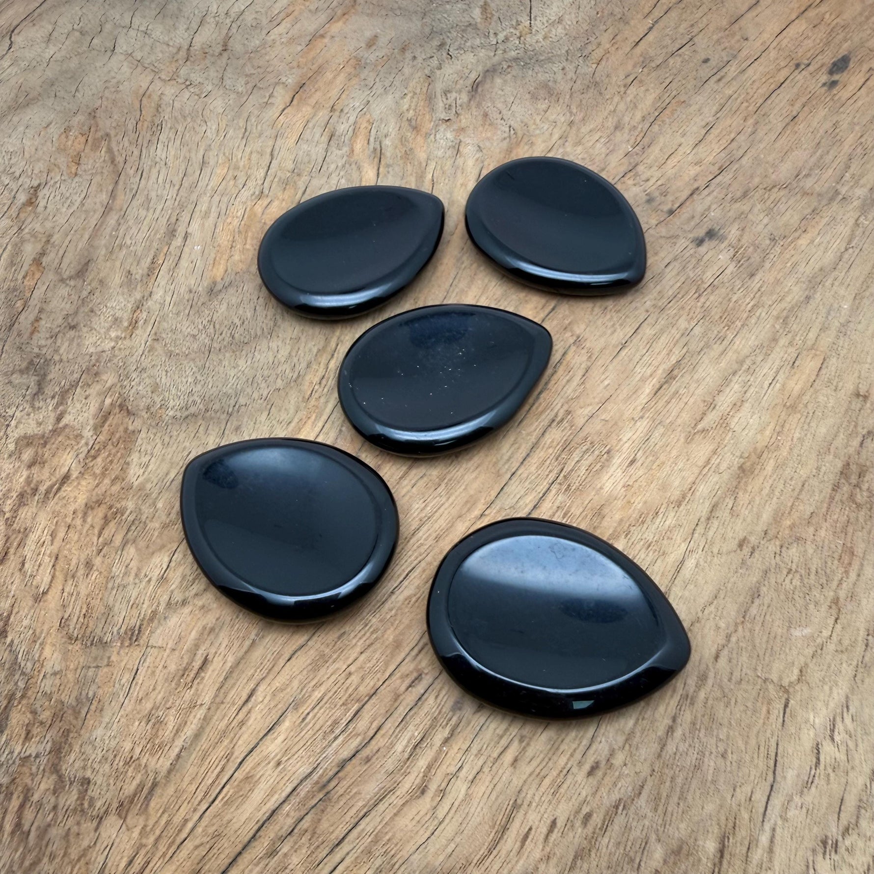 Obsidian worry stone from GemstoneGO, 45mm smooth crystal for stress relief, shown in close-up with polished surface and natural black color.