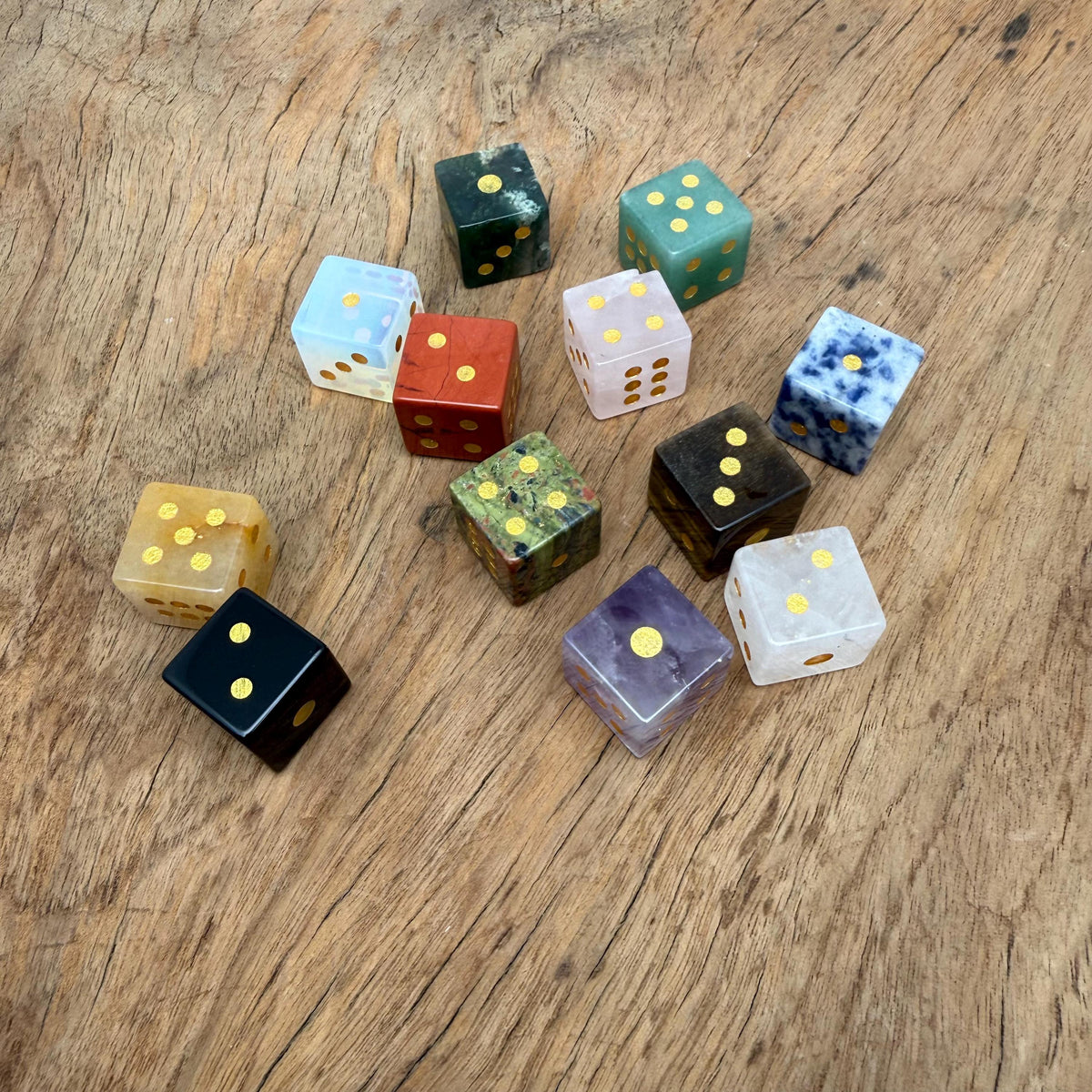 Polished gemstone crystal dice set by GemstoneGO featuring carved multi-colored dice for metaphysical use and gaming.