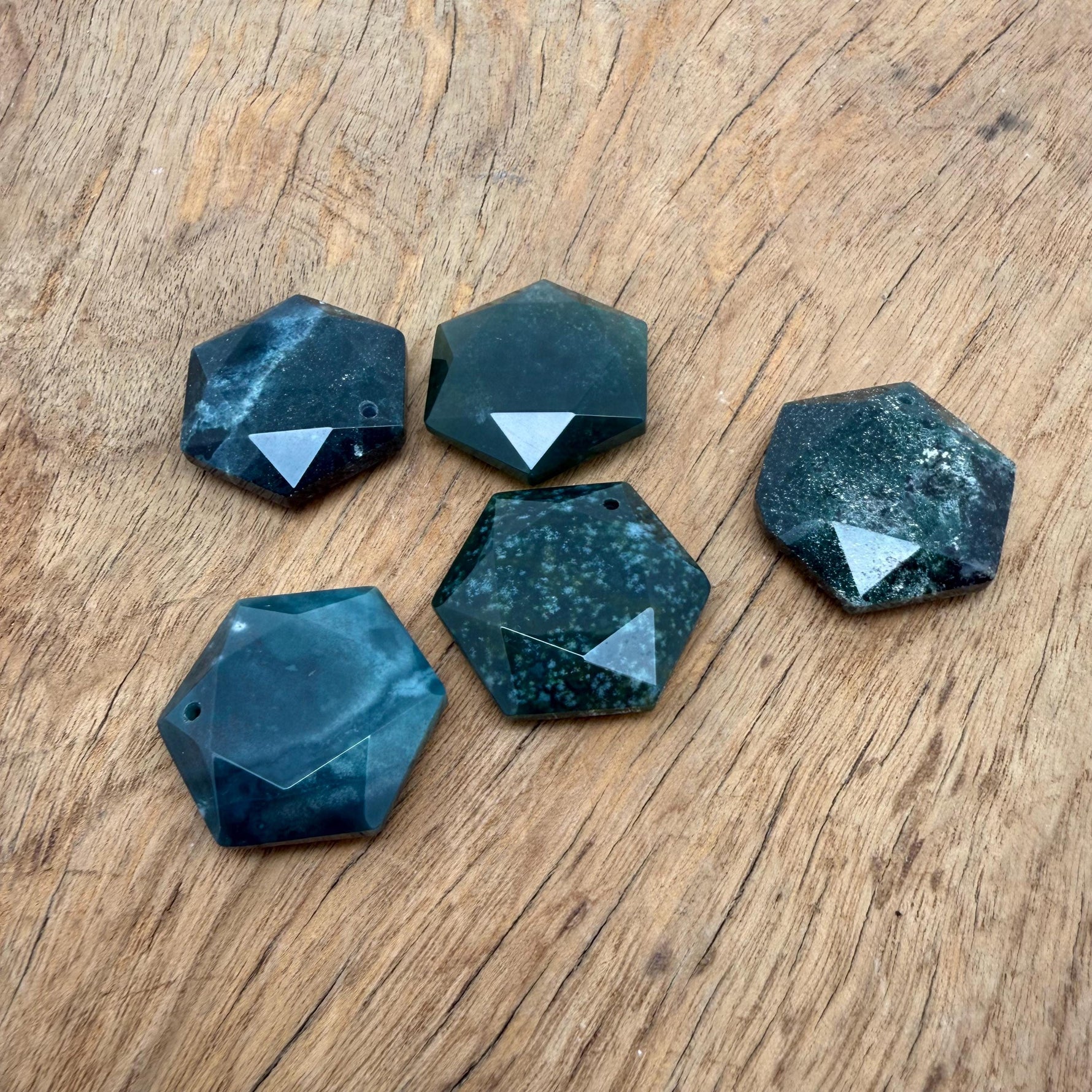 Faceted moss agate hexagon crystal pendant necklace with a polished stone bead, showcasing natural green and brown gemstone details.