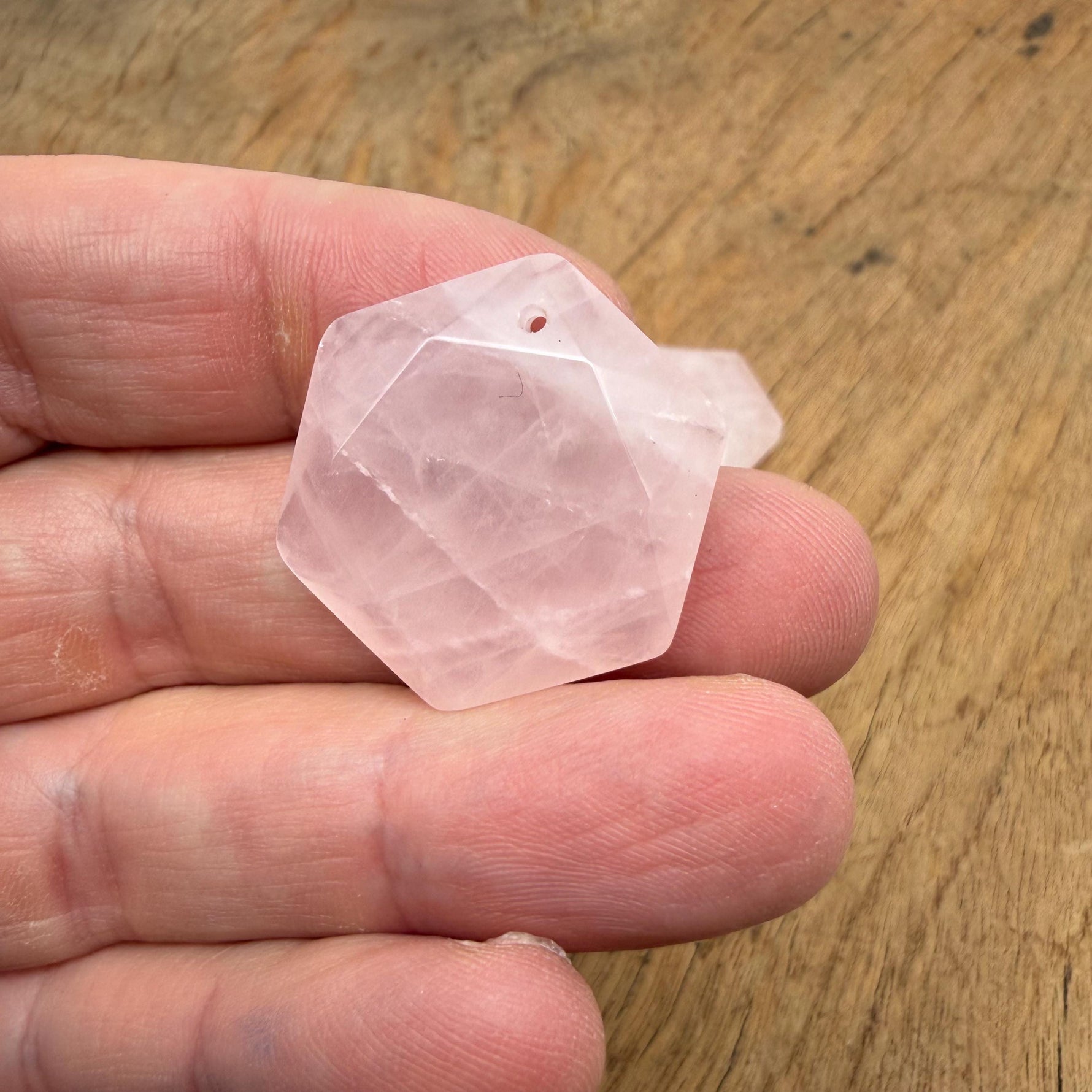 Faceted rose quartz hexagon crystal pendant necklace with gemstone bead, showcasing a pink, polished stone on a delicate chain.